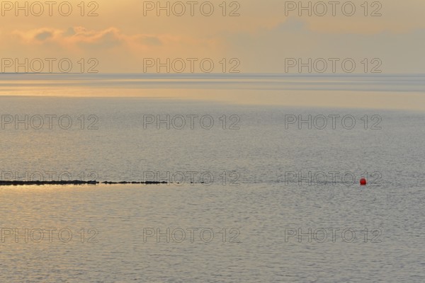 Evening mood at the Wadden Sea, stone groyne with red buoy, North Sea, Norddeich, Lower Saxony, Germany