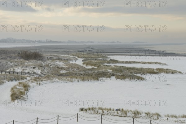 View over the snow-covered dune landscape of Norddeich, Wadden Sea at low tide, North Sea, Lower Saxony, Germany