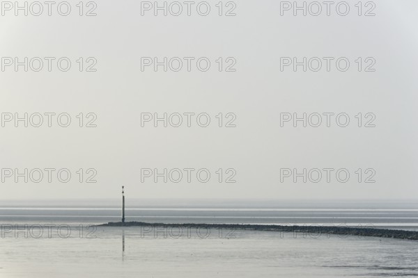 North Sea coast, cloudy winter day, Wadden Sea at low tide, stone groyne with sea mark, North Sea, Norddeich, Lower Saxony, Germany