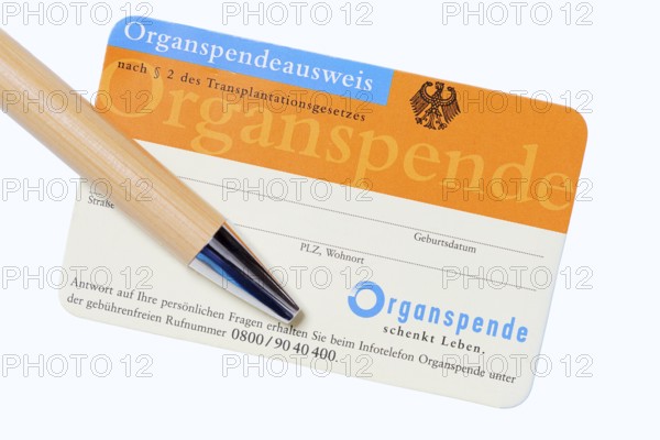 Organ donor card with biros on white background, symbolic image of organ donation