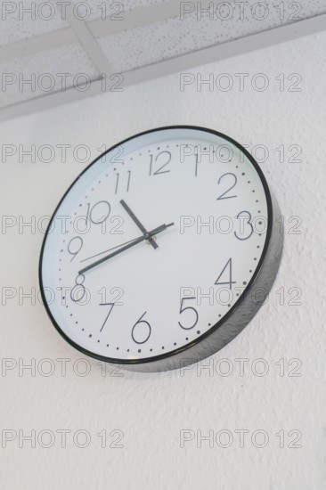 Round wall clock with white dial and black hands, Care Connect, vaccination kiosk for refugees, Calw, Germany