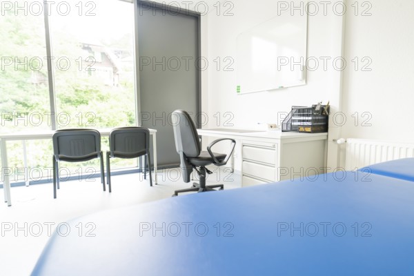 Bright office space with desk and chairs in front of large windows, Care Connect, vaccination kiosk for refugees, Calw, Germany