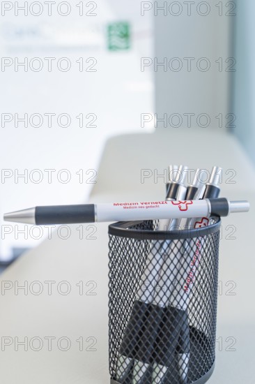 Pen holder filled with pens on a desk, Care Connect, vaccination kiosk for refugees, Calw, Germany