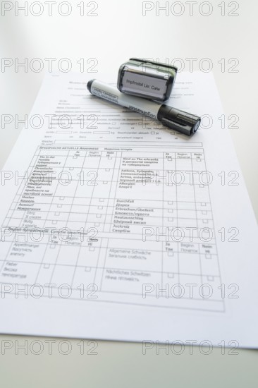 Form on a desk with stamp and marker, Care Connect, vaccination kiosk for refugees, Calw, Germany