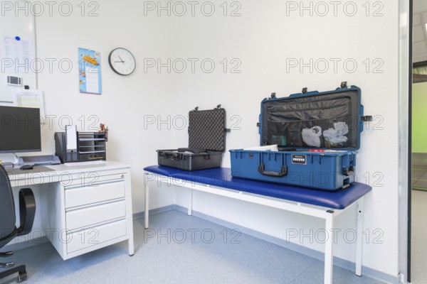 A meeting room with two suitcases, table and clock, Care Connect, vaccination kiosk for refugees, Calw, Germany