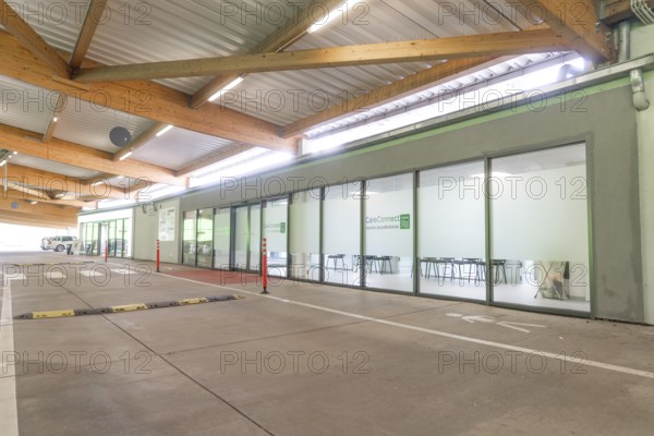 Modern building with glass front and car park at CareConnect, Care Connect, vaccination kiosk for refugees, Calw, Germany