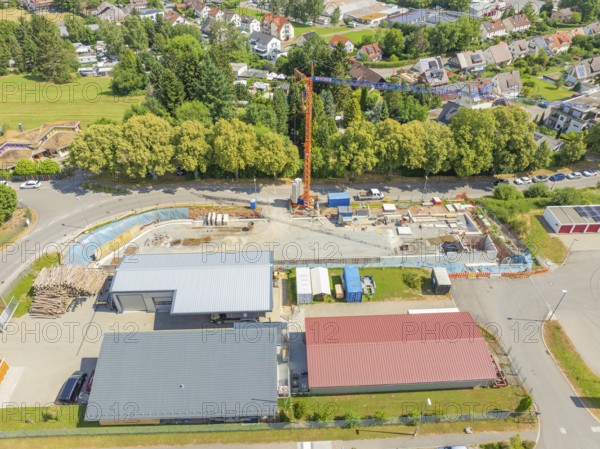 Crane over a construction site in a village landscape with many houses, car park construction, Calw, Germany