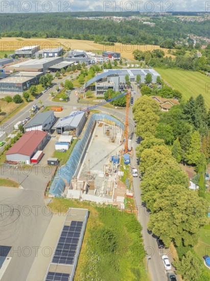 Crane near a construction site with surrounding greenery and buildings, car park construction, Calw, Germany