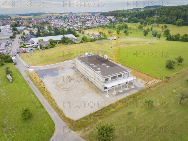 Aerial view shows a building under construction in a rural area, green roof, house construction, climate neutral