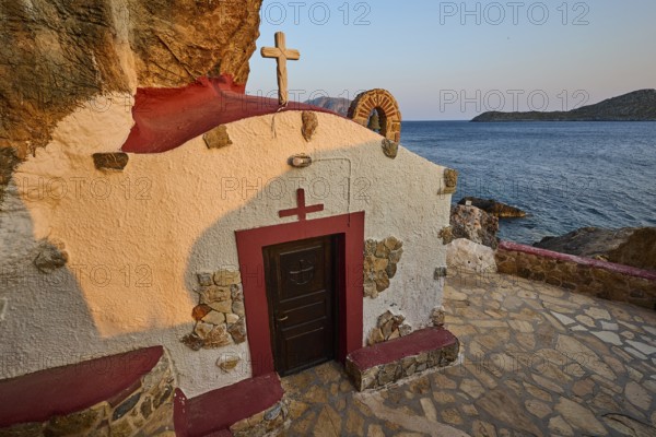 Legend, crab, shell fisherman, chapel with red roof and cross, directly on the rocky coast to the sea, illuminated by the sunset, chapel, little church, Agia Kavouradena monastery, Xirokambos, Leros, Dodecanese, Greek Islands, Greece