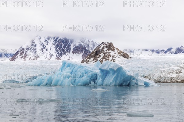 Iceberg in front of glacier tongue, sea, mountain range, Smeerenburgbreen, Spitsbergen, Svalbard