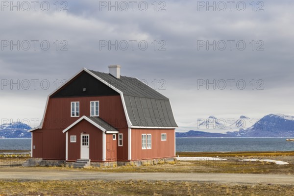 Wooden house in front of a mountain range, Ny-Alesund, Spitsbergen, Svalbard