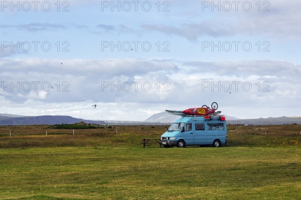 Motorhome with sports equipment on the roof, campsite in Selvogur, south coast, Iceland
