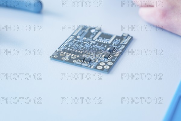 Close-up of a circuit board on a table in focus, blurred background