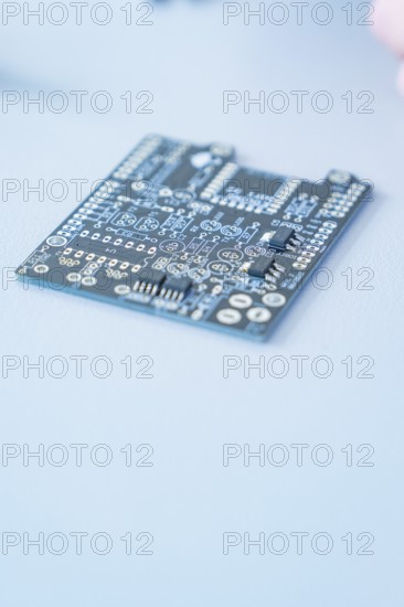Close-up of a printed circuit board on a blue background with visible circuits