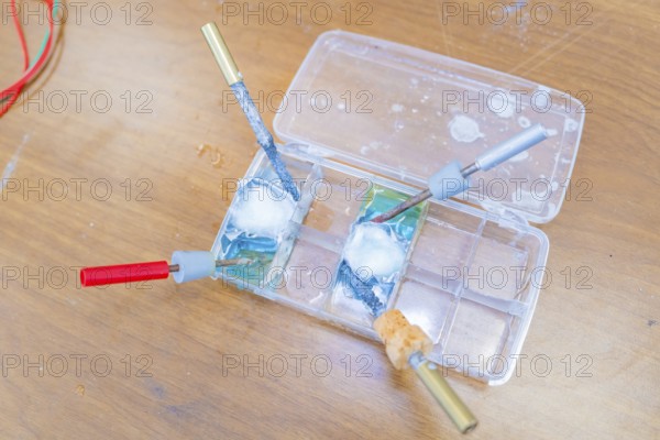 Electrical experiment with wires and a liquid in trays in the laboratory, Battery Research, Nagold, Germany