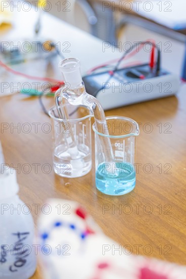 Chemical laboratory with beakers containing a clear and a blue liquid, Battery Research, Nagold, Germany