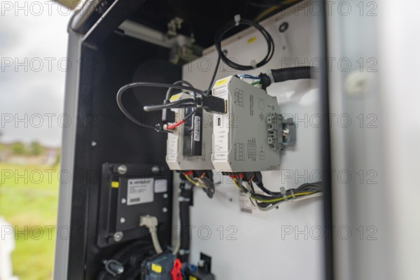 Open switch box with cables and background landscape outdoors, installation of a charging station for electric cars, Calw, Germany