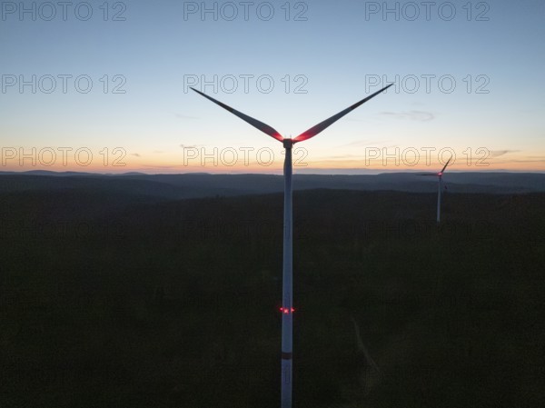 A wind turbine in front of a colourful evening sky with the silhouette in the darkness, Simmersfeld, Black Forest, Germany