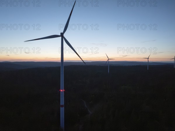 Several wind turbines on the horizon during a sunset, the sky is coloured in warm tones, Simmersfeld, Black Forest, Germany