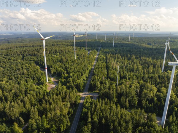 Several wind turbines along a path through a green forest under a blue sky, Simmersfeld, Black Forest, Germany