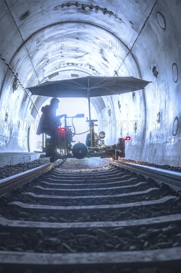 Machine used in the tunnel with umbrella-like construction on rails, surrounded by light and shadow, grinding work on the Hermann Hesse railway, Ostelsheim, district of Calw, Germany