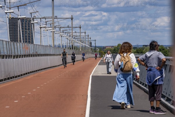 Cycle and pedestrian bridge Snelbinder Brug, over the river Waal near Nijmegen, was added to the existing railway bridge, fast cycle path connection from the city centre of Nijmegen and the new housing estates in the Waalsprong district, Netherlands