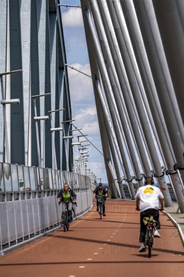 Cycle and pedestrian bridge Snelbinder Brug, over the river Waal near Nijmegen, was added to the existing railway bridge, fast cycle path connection from the city centre of Nijmegen and the new housing estates in the Waalsprong district, Netherlands