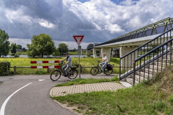 De Massover cycle path bridge, over the Meuse south of Nijmegen, near Cuijk, part of the MaasWaalpad long-distance cycle path, 12 km between Nijmegen and Cuijk, built in 2021, for 15 million euros, Meuse river crossing for cyclists and pedestrians, part of a cycle path network, used by many commuters, next to a railway bridge, Netherlands