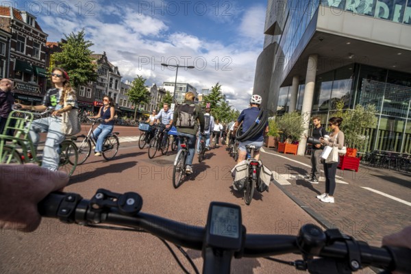 Ride your bike on the central cycle path on Lange Viestraat, Vredenburg, in the city centre of Utrecht, lanes for pedestrians, cyclists and public transport vehicles are separated, heavy cycle traffic, Netherlands