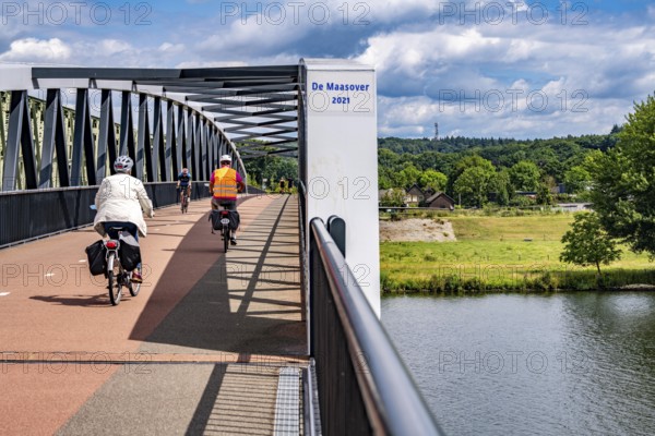 De Massover cycle path bridge, over the Meuse south of Nijmegen, near Cuijk, part of the MaasWaalpad long-distance cycle path, 12 km between Nijmegen and Cuijk, built in 2021, for 15 million euros, Meuse river crossing for cyclists and pedestrians, part of a cycle path network, used by many commuters, next to a railway bridge, Netherlands