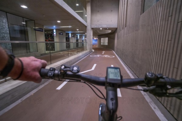 Ride your bike into and out of the bicycle car park at Utrecht Centraal station, Stationsplein, over 13, 000 parking spaces, considered the largest bicycle car park in the world, over 3 underground floors, Utrecht, Netherlands