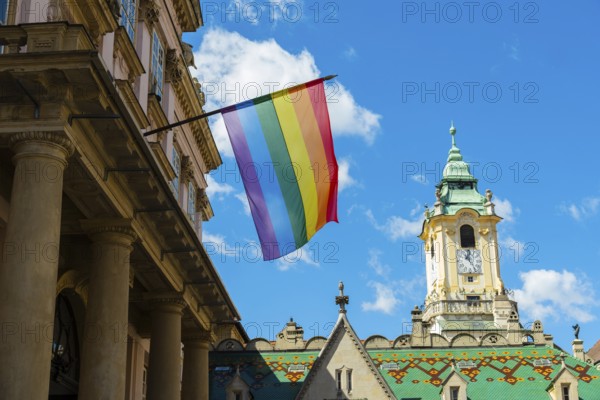 Rainbow flag on the Primatial Palace, in the background is the Old Town Hall of Bratislava, Slovakia