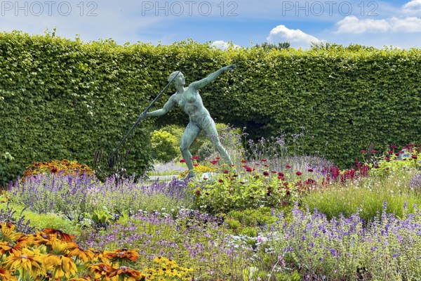 Sculpture Statue of bronze javelin thrower from 1937 by sculptor and artist Ernst Seger in flower roundabout Lindenrund in Grugapark Essen, Essen, North Rhine-Westphalia, Germany