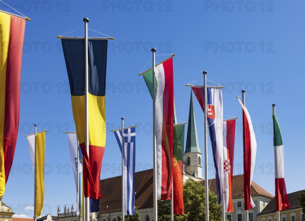 National flags at Kapellplatz with the collegiate parish church of St Philip and St James, place of pilgrimage, Altötting, Upper Bavaria, Bavaria, Germany
