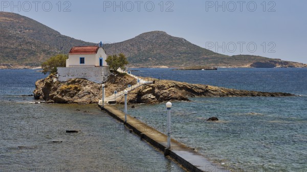 Whitewashed chapel with red roof on island in blue sea under sunny sky, chapel, church, Agios Isidoros, rocky islet, bay of Gourna, Kokkali, Leros, Dodecanese, Greek Islands, Greece