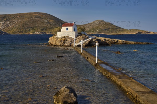 White chapel with red roof on rocky island, accessible via a long footbridge, chapel, church, Agios Isidoros, rocky islet, Bay of Gourna, Kokkali, Leros, Dodecanese, Greek Islands, Greece