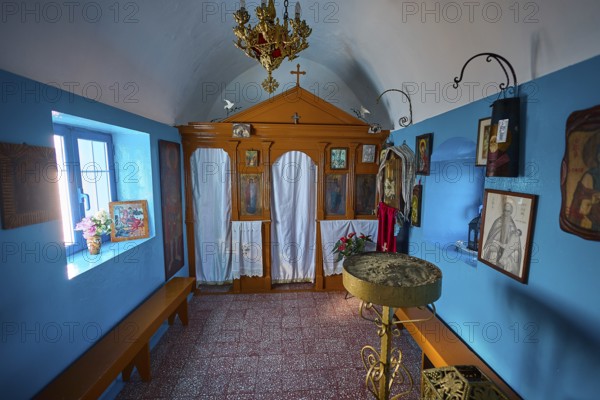 The interior of the church features icons and decorative elements in blue and orange, chapel, church, Agios Isidoros, rocky islet, Gourna Bay, Kokkali, Leros, Dodecanese, Greek Islands, Greece