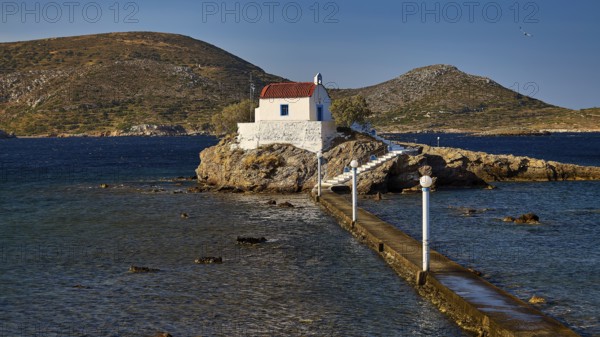 Chapel on an island, framed by blue sky and mountains, with access via a footbridge, Chapel, Church, Agios Isidoros, Rocky islet, Bay of Gourna, Kokkali, Leros, Dodecanese, Greek Islands, Greece
