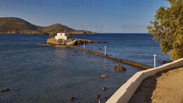Small chapel on rock, surrounded by trees, in quiet morning light, chapel, church, Agios Isidoros, rocky islet, Bay of Gourna, Kokkali, Leros, Dodecanese, Greek Islands, Greece