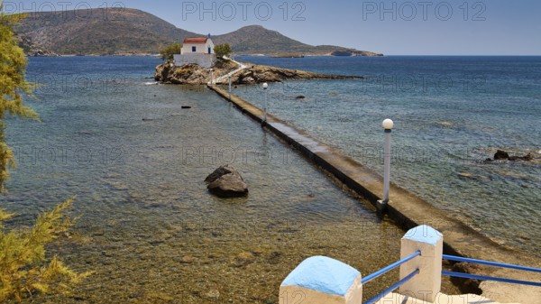 Rocky coast with chapel, surrounded by clear water and hilly island landscape, Chapel, Church, Agios Isidoros, Rocky islets, Bay of Gourna, Kokkali, Leros, Dodecanese, Greek Islands, Greece