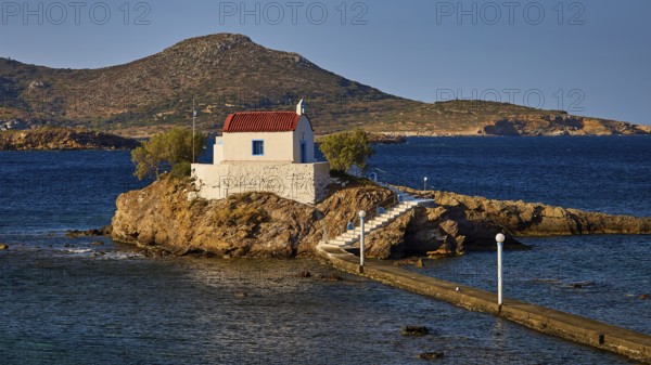 Chapel on rocks as the landscape is bathed in warm light, Chapel, Church, Agios Isidoros, Rocky islet, Bay of Gourna, Kokkali, Leros, Dodecanese, Greek Islands, Greece