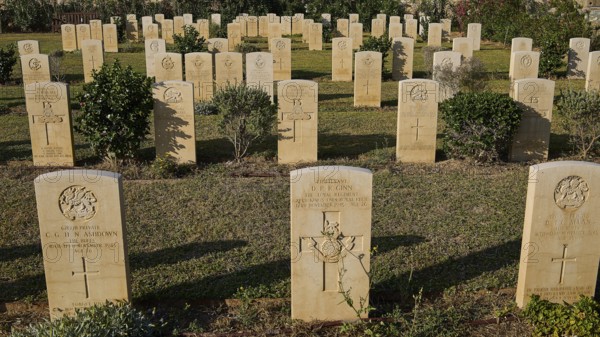 Rows of carefully tended gravestones in a cemetery in sunlight with green vegetation, Military Cemetery, Commonwealth War Cemetery, Military Cemetery, WW2, 1939-1945, 179 graves, Alinda, Leros, Dodecanese, Greek Islands, Greece