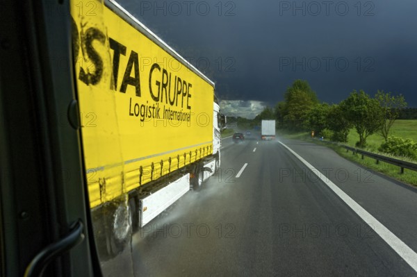 Overtaking manoeuvre of articulated lorry, lorry overtaking in thunderstorm, heavy rain, poor visibility, black sky, aquaplaning, A9 motorway near Pfaffenhofen, Upper Bavaria, Bavaria, Germany