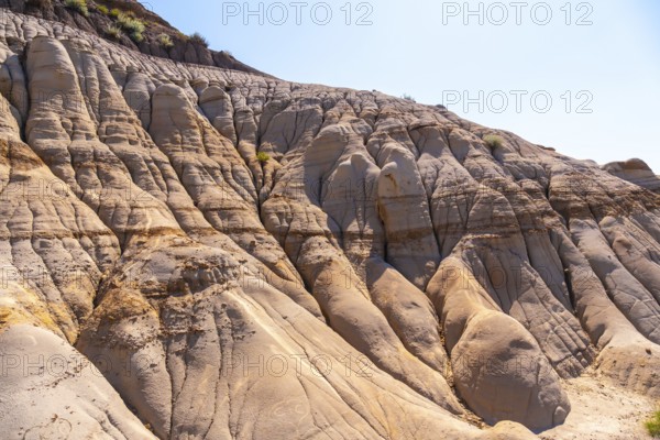 Sunlight illuminates the unique geological formations known as hoodoos. Showcasing layers of sedimentary rock and erosion patterns in drumheller. Alberta. A testament to the power of nature over time