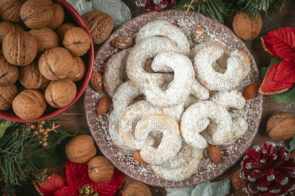 Vanilla croissants on a plate next to walnuts and Christmas decoration