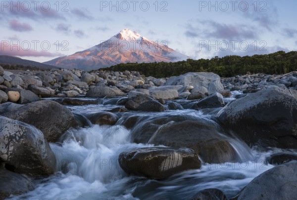 Mount Taranaki in the evening at sunset, in the foreground Stony River (Hangatahua River) . Egmont National Park, Taranaki Region, North Island, New Zealand