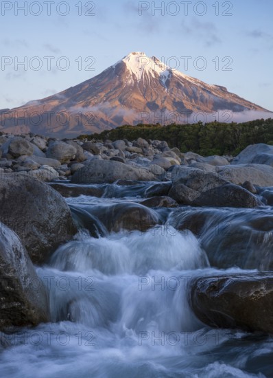Mount Taranaki in the evening at sunset, in the foreground Stony River (Hangatahua River) . Egmont National Park, Taranaki Region, North Island, New Zealand