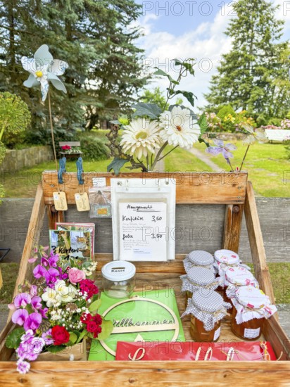 Table for sale of postcards and marmalade with floral decorations and treasury of trust, Hullerbusch Nature Reserve, Carwitz, Feldberger Seenlandschaft, Mecklenburg Lake District in Mecklenburg-Western Pomerania, Germany
