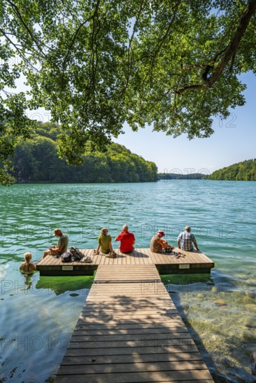 People on a boat dock and in turquoise blue water, Schmaler Luzin Lake, Feldberg Lake District, Mecklenburg Lake District, Mecklenburg-Western Pomerania, Germany